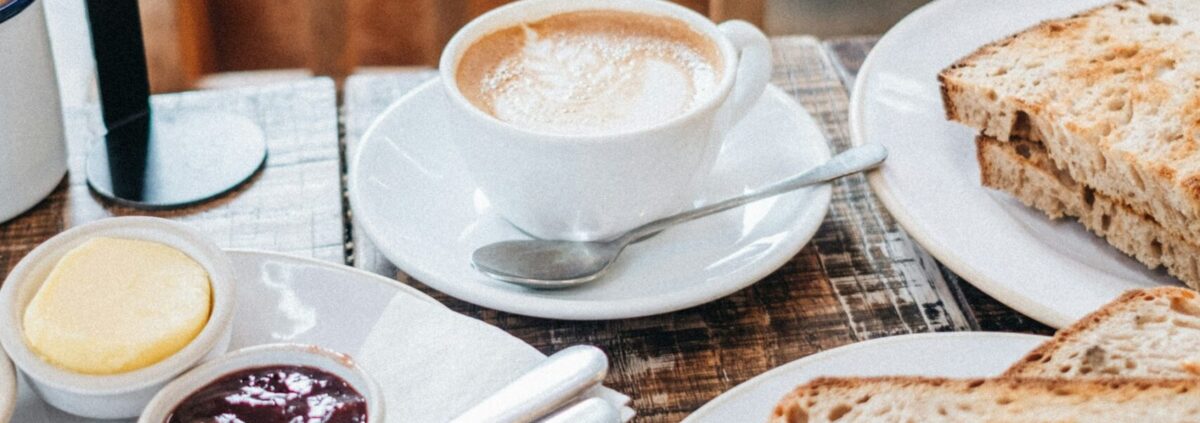 Foto „Tasse Milchkaffee und geschnittenes Brot“ von Sonnie Hiles @ Unsplash